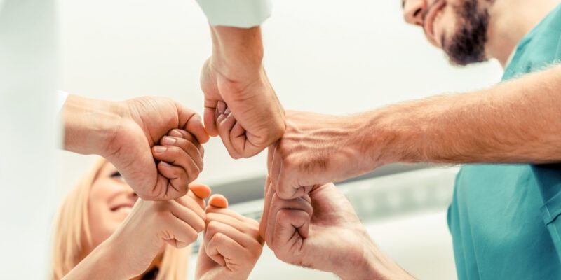 Teamarbeit im medizinischen Dienst - Arzt, Chirurg und Krankenschwester reichen sich die Hände. Teamarbeit im medizinischen Dienst - Arzt, Chirurg und Krankenschwester reichen sich die Hände.