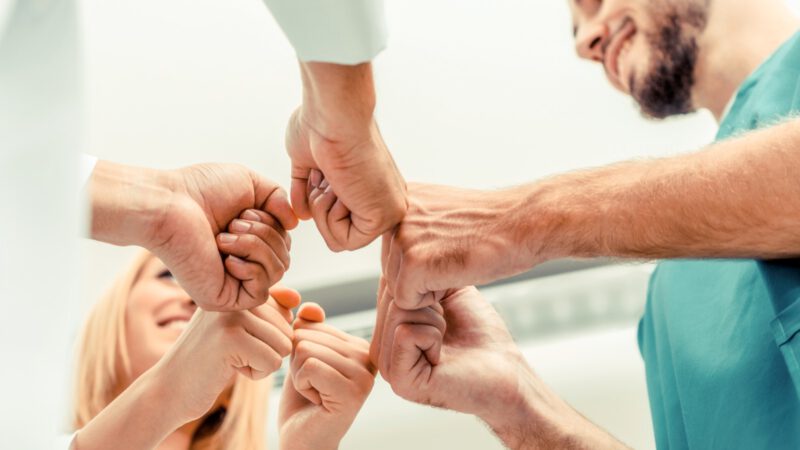 Teamarbeit im medizinischen Dienst - Arzt, Chirurg und Krankenschwester reichen sich die Hände. Teamarbeit im medizinischen Dienst - Arzt, Chirurg und Krankenschwester reichen sich die Hände.