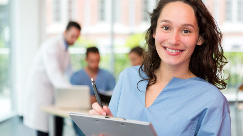 Portrait of a young attractive nurse at the hospital Junge Pflegerin arbeitet am Tablet