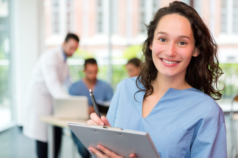 Portrait of a young attractive nurse at the hospital Junge Pflegerin arbeitet am Tablet